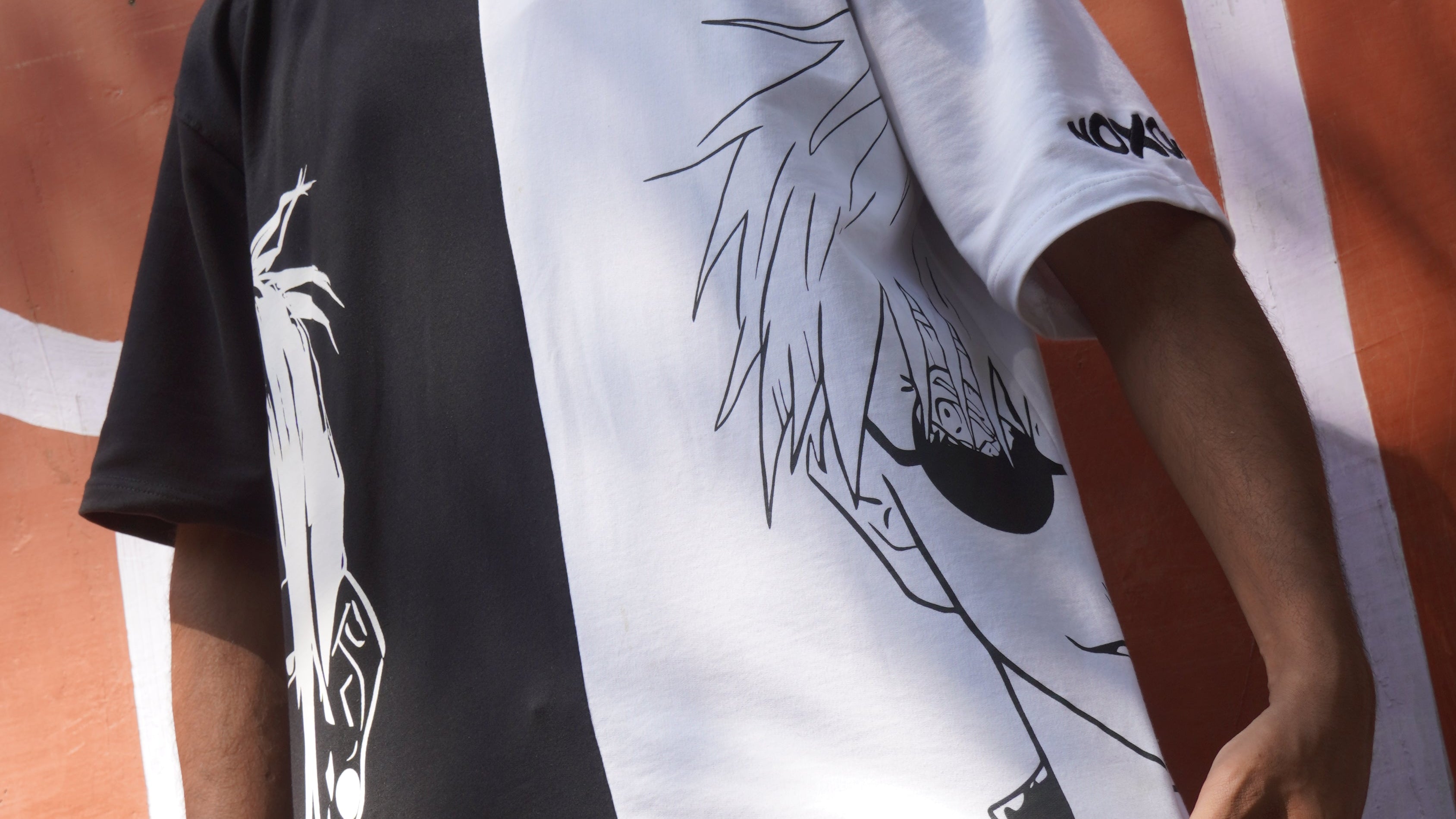 Person holding a black and white graphic t-shirt on a basketball court